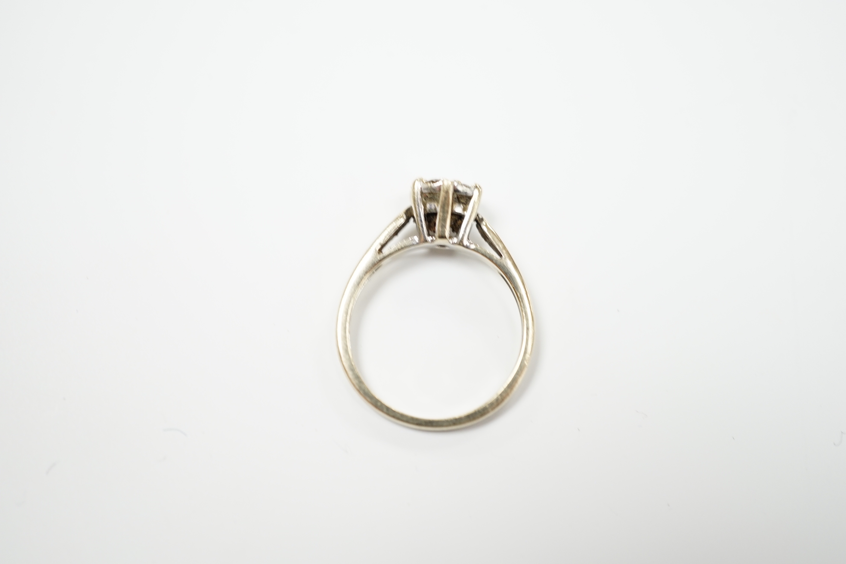 A 750 white metal and seven stone diamond set circular cluster ring, size M, gross weight 3.2 grams.